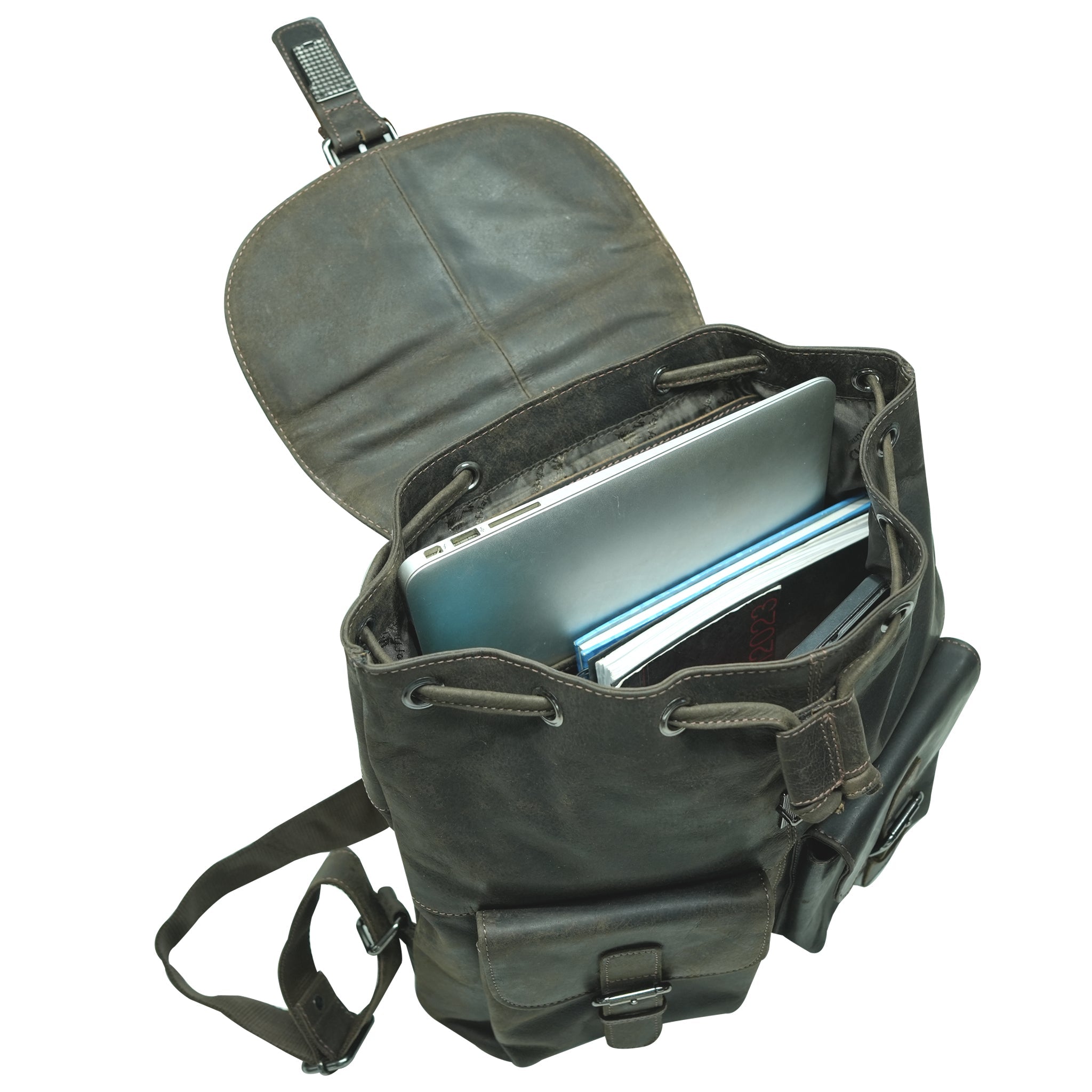 Brown leather backpack open with laptop and books inside
