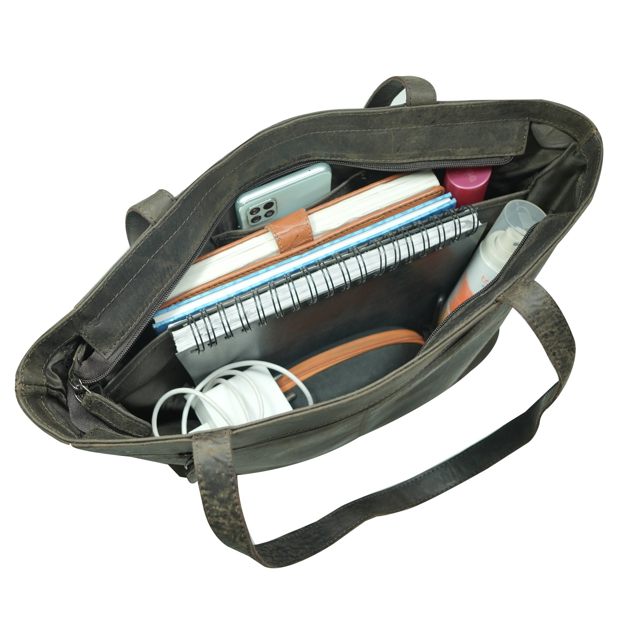 Open bag with various items including a notebook and phone on a white background